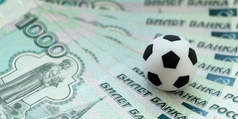 pinigai ir futbolo kamuolys